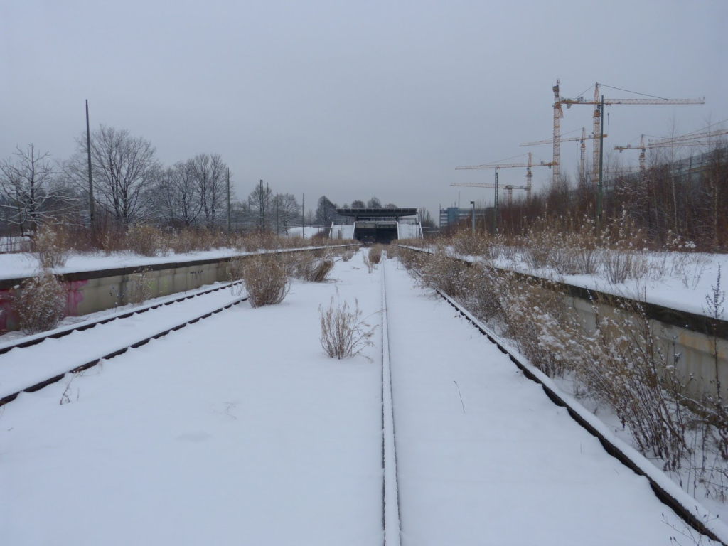 Verlassene, schneebedeckte Bahngleise am ehemaligen Bahnhof Olympiastadion München im Winter
