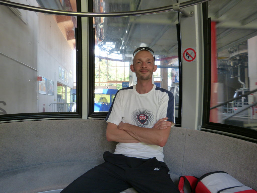 Mann sitzt entspannt in der Gondel der Alpspitzbahn am Zugspitzmassiv