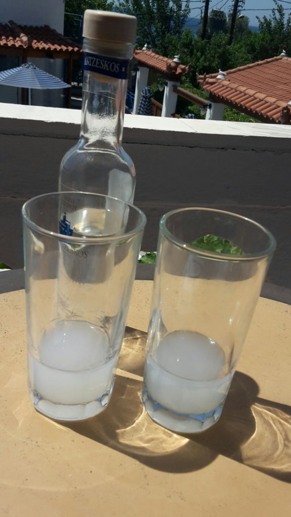 Ouzo-Flasche Anizeskos mit zwei Gläsern und runden Eiswürfeln auf Samos