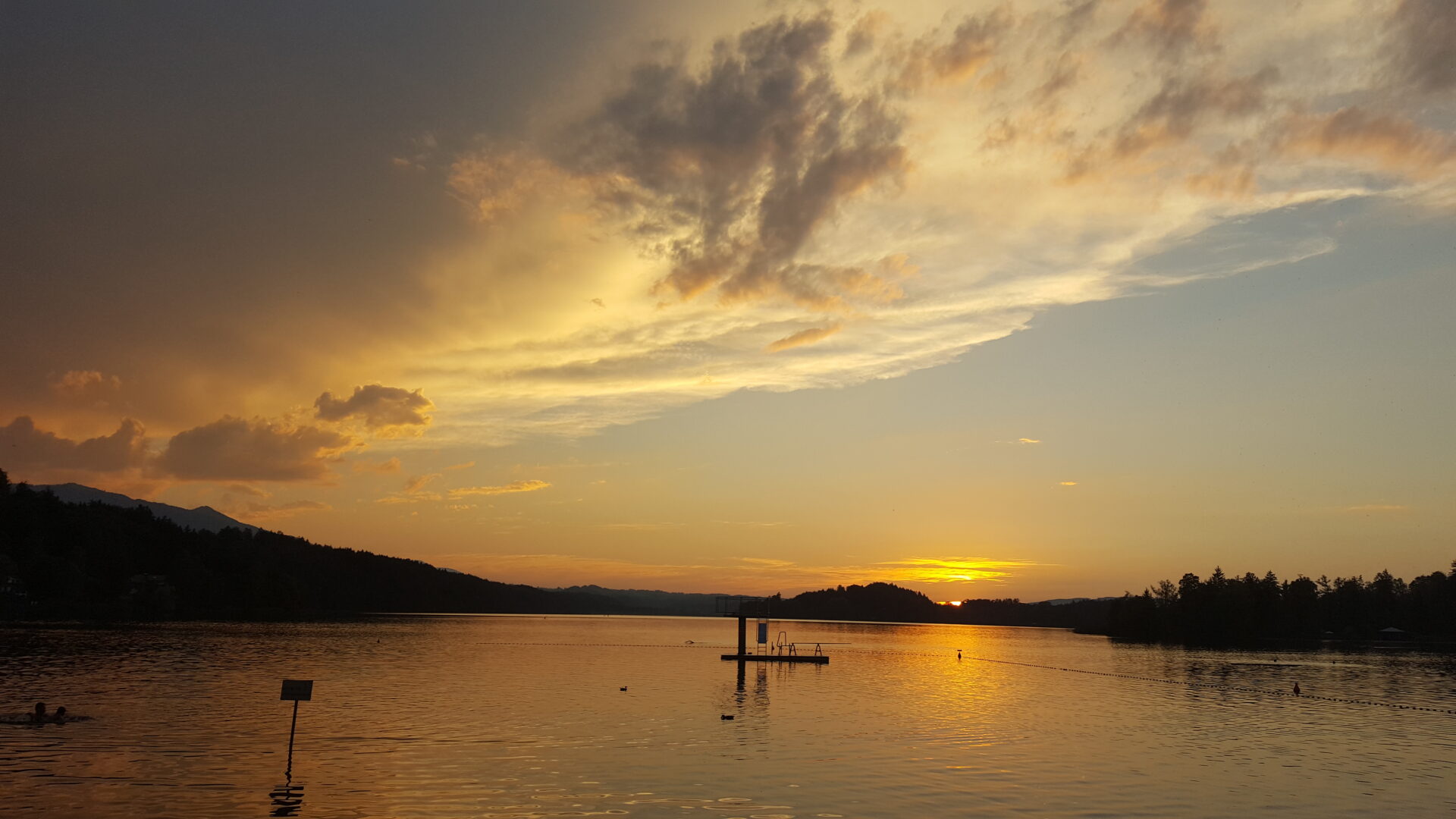 Sonnenuntergang über dem Staffelsee bei Murnau mit Badeplattform und Bergsilhouette