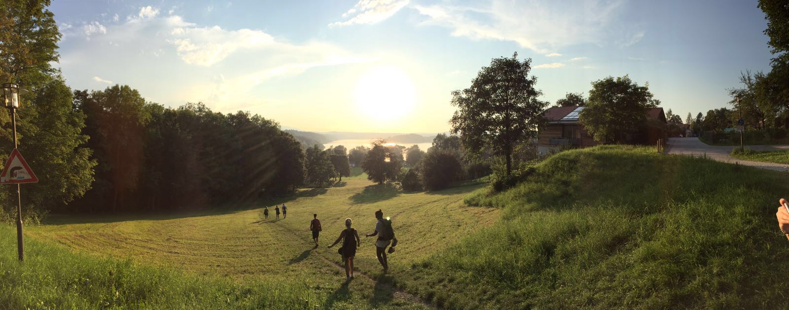 Wandergruppe auf Wiesenpfad bei Sonnenuntergang nahe Murnau am Staffelsee