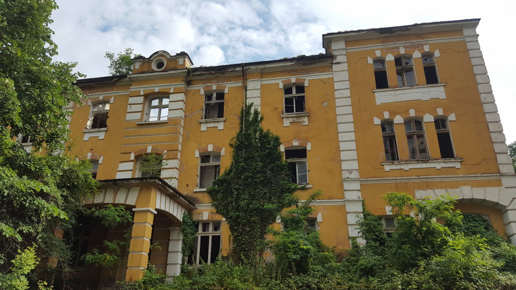 Verlassenes gelbes Gebäude mit eingewachsener Fassade nahe Kloster Tscherepisch