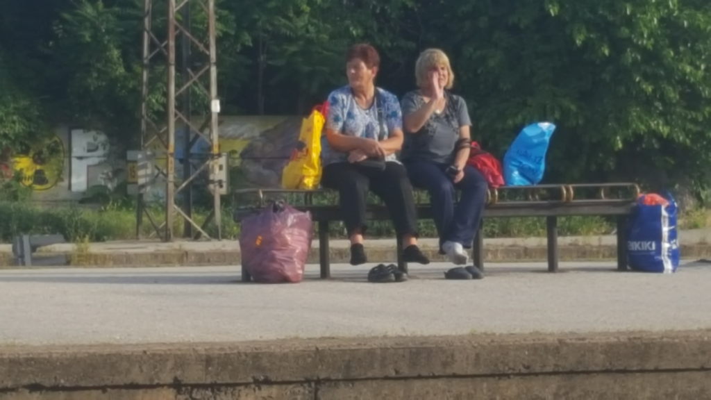 Zwei Frauen sitzen mit Einkaufstaschen auf einer Bank am Bahnhof Plovdiv