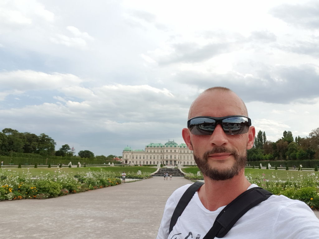 Selfie eines Mannes mit Sonnenbrille vor Schloss Belvedere in Wien