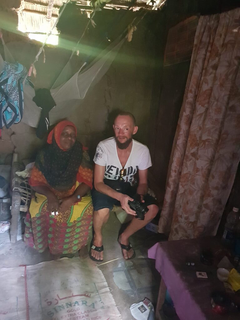 Reiseblogger mit einheimischer Frau in einfacher Hütte im Dorf Mchangani, Sansibar