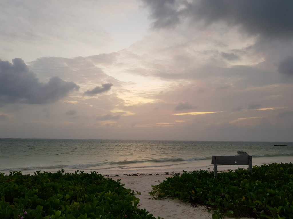 Sansibar Strand bei bewölktem Sonnenaufgang mit türkisem Meer und weißem Sand