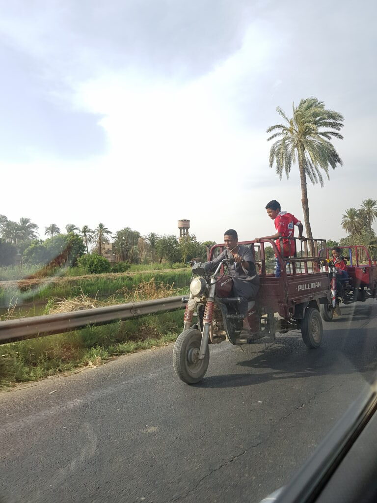 Motorrad-Dreirad mit zwei jungen Männern auf ägyptischer Landstraße bei Luxor