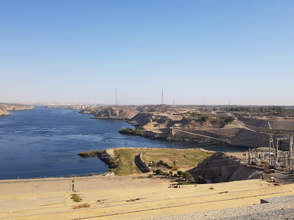 Panoramablick vom Assuan-Hochdamm auf den Nil mit Felsen und Strommasten