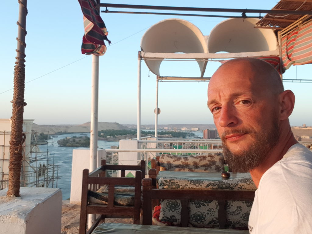 Mann auf Rooftop-Terrasse mit Blick auf den Nil in Assuan beim Abendessen