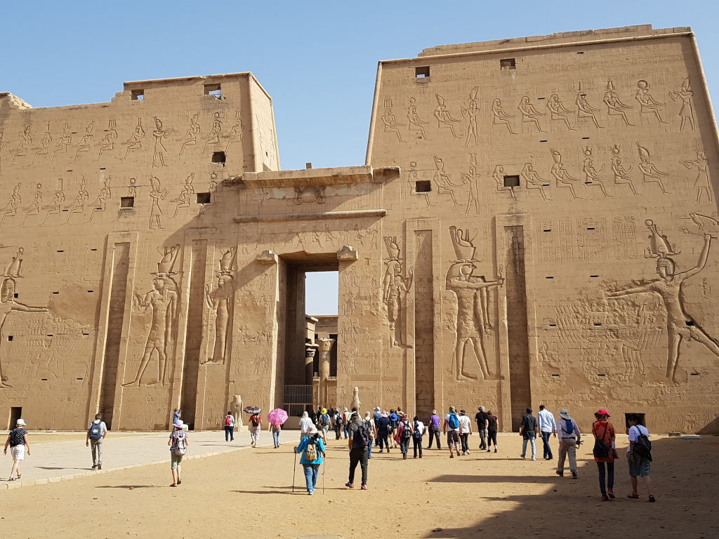 Beeindruckender Eingangspylon des Horus-Tempels in Edfu mit Hieroglyphen und Touristen
