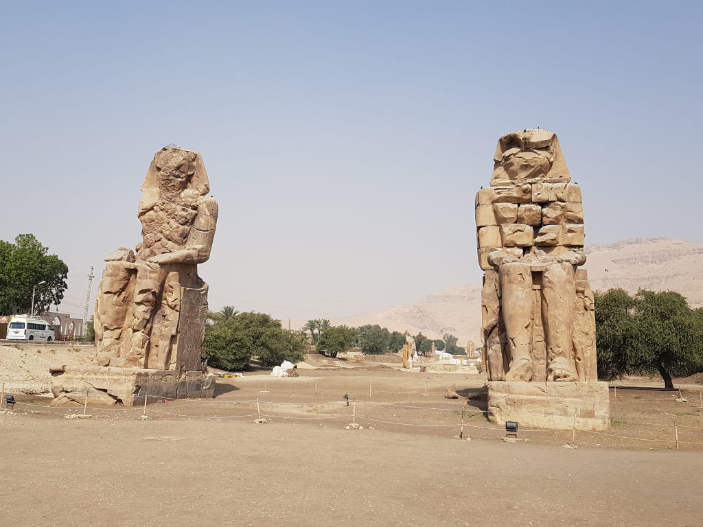 Die zwei riesigen Kolosse von Memnon in Luxor, Ägypten, vor blauem Wüstenhimmel