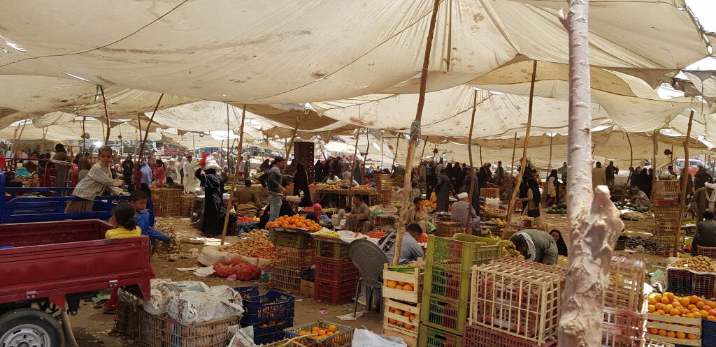 Belebter Obst- und Gemüsemarkt in Luxor unter großen Stoffplanen mit vielen Händlern