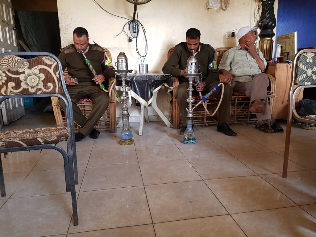Zwei Männer in Uniform rauchen Wasserpfeife in einem lokalen Café in Luxor, Ägypten