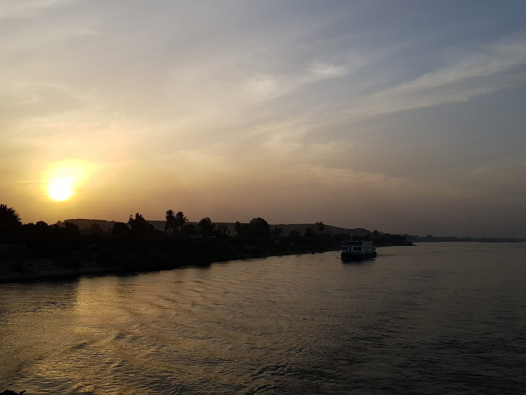 Sonnenuntergang über dem Nil bei Luxor mit Kreuzfahrtschiff im Abendlicht