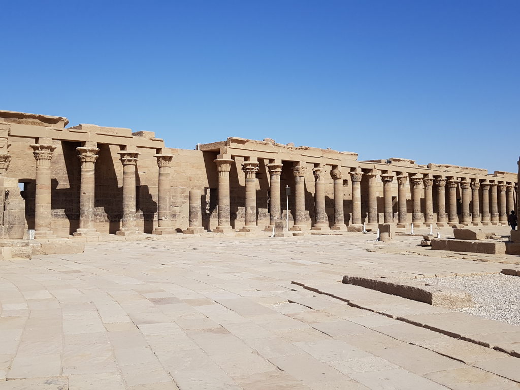 Langer Säulengang des Philae-Tempels in Assuan unter strahlend blauem Himmel