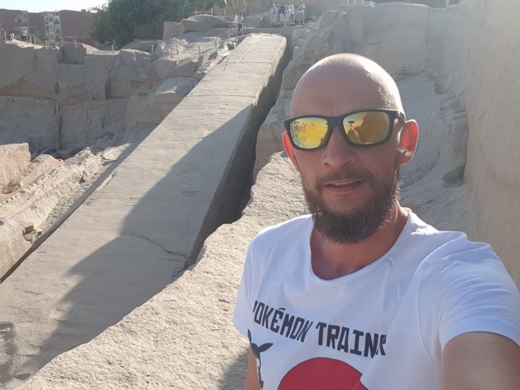 Mann mit Sonnenbrille macht Selfie am Unvollendeten Obelisken in Assuan, Ägypten
