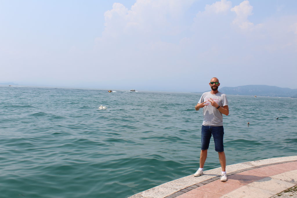 Mann posiert an der Uferpromenade von Lazise am Gardasee, Italien