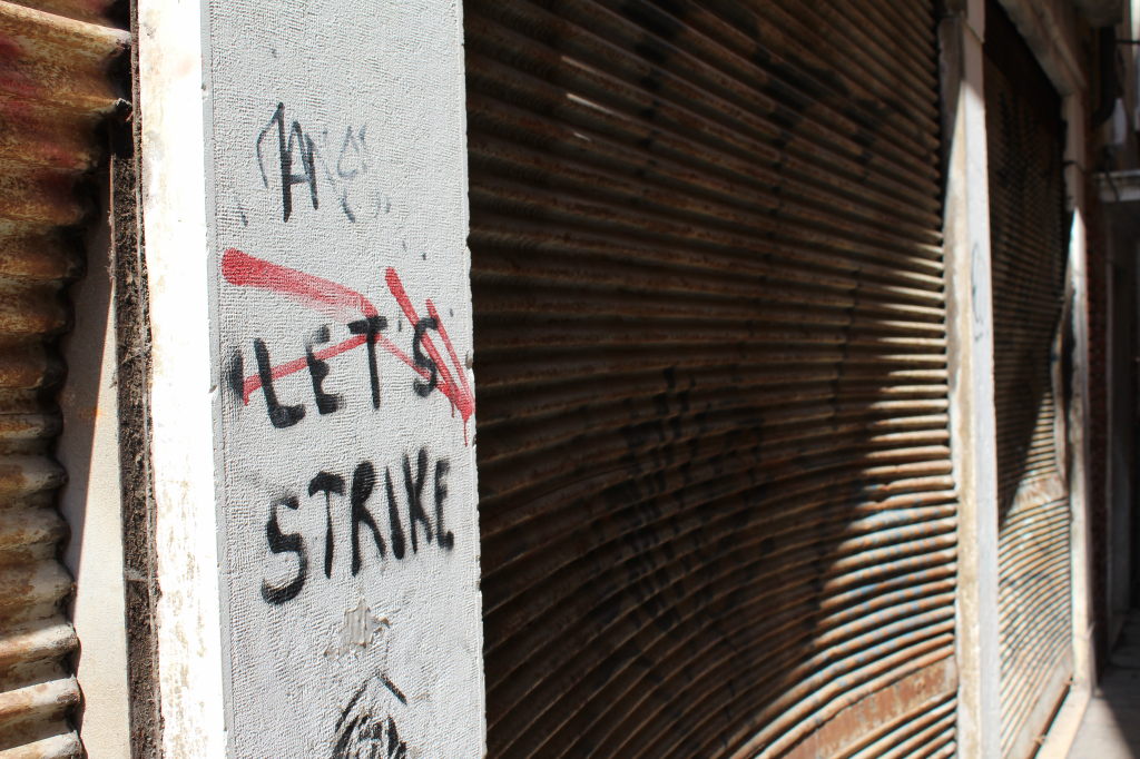 Graffiti mit Aufschrift Let's Strike' an rostigen Rollläden in Venedig