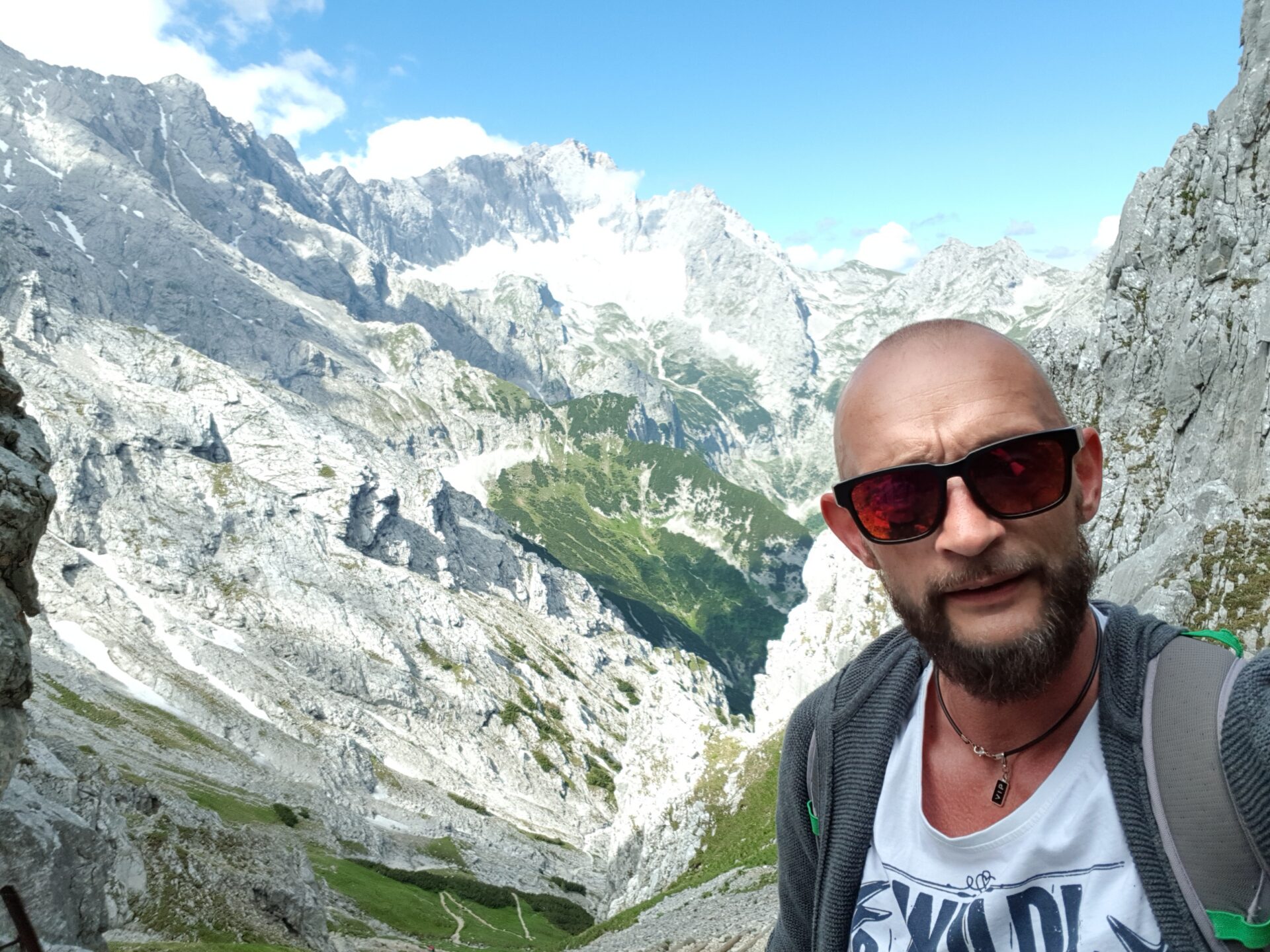 Wanderer mit Sonnenbrille macht Selfie vor alpinem Bergpanorama im Höllental