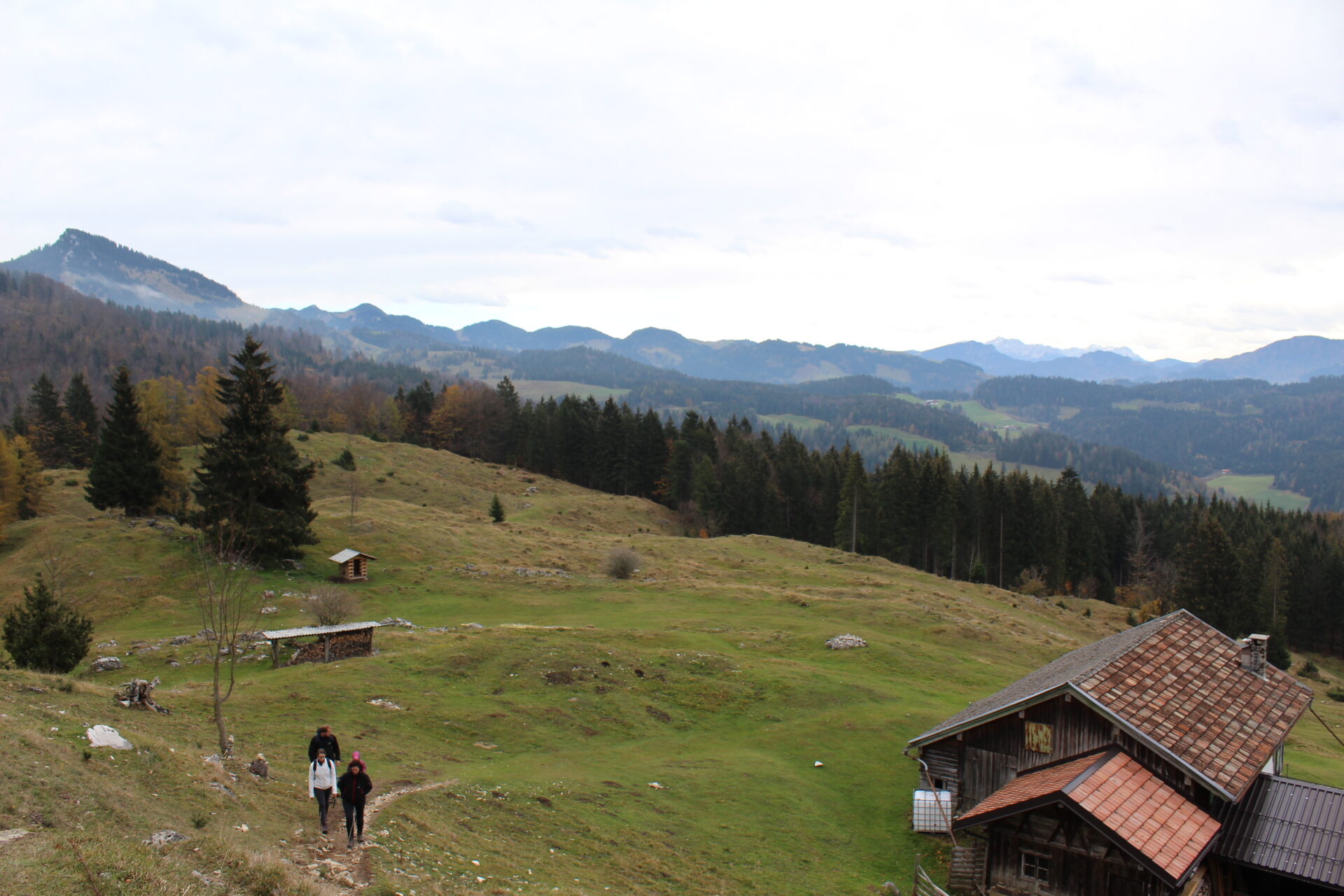 Wanderer auf der Kranzhorn Alm mit Bergpanorama im Herbst