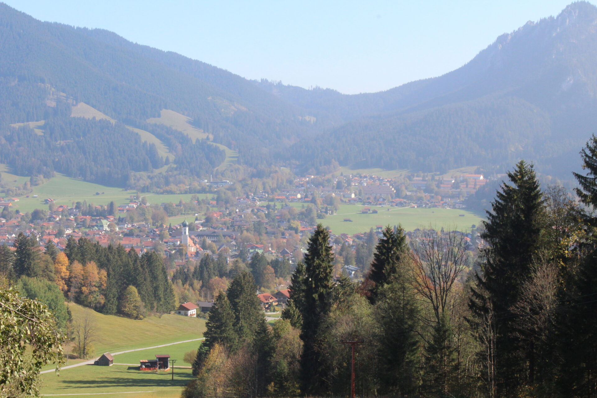 Panoramablick auf Oberammergau im Herbst mit Kirchturm und Alpen