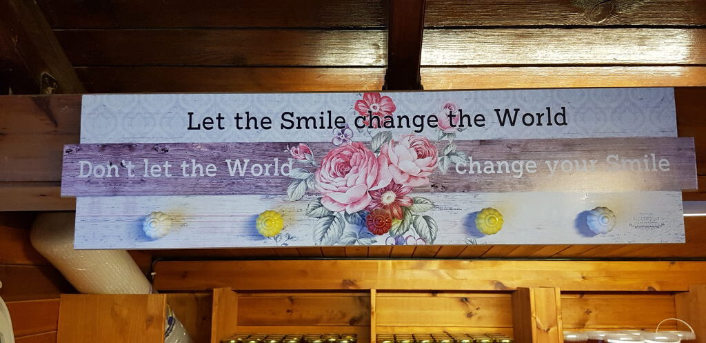 Dekoratives Holzschild mit Rosen und Motivationsspruch im Kafe-Yozeri Kastro, Nikiti