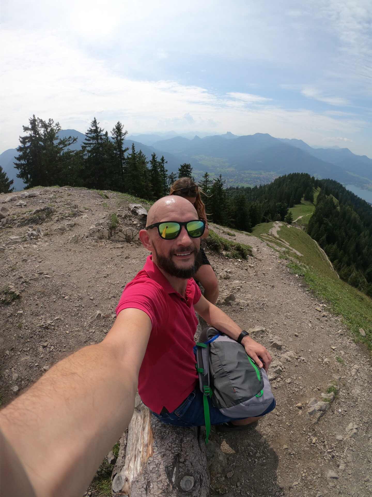 Gipfelselfie auf dem Baumgartenschneid mit Tegernsee im Hintergrund und bewölktem Himmel