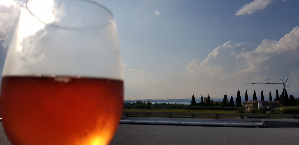 Glas Roséwein auf Terrasse mit Blick auf den Gardasee und Zypressen