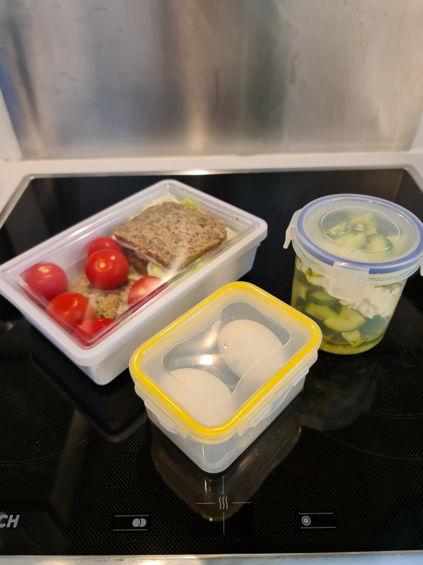 Wanderproviant in Lunchboxen: Brot mit Tomaten, hartgekochte Eier und Gurkensalat