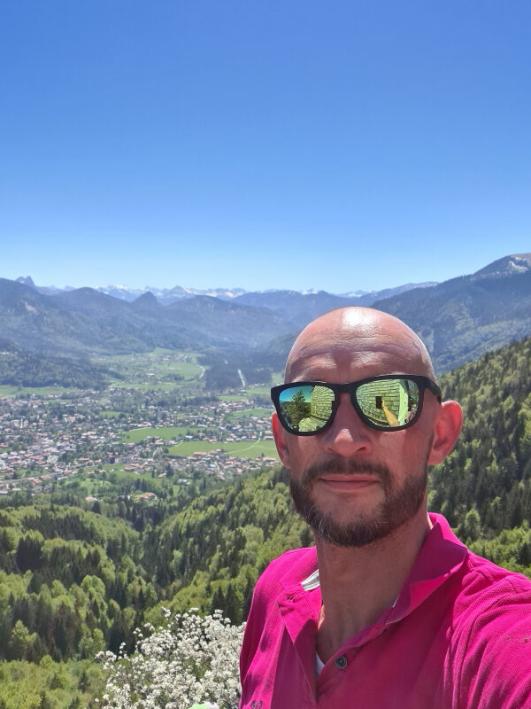 Sebastian mit Sonnenbrille vor dem Panorama des Tegernsees am Riederstein