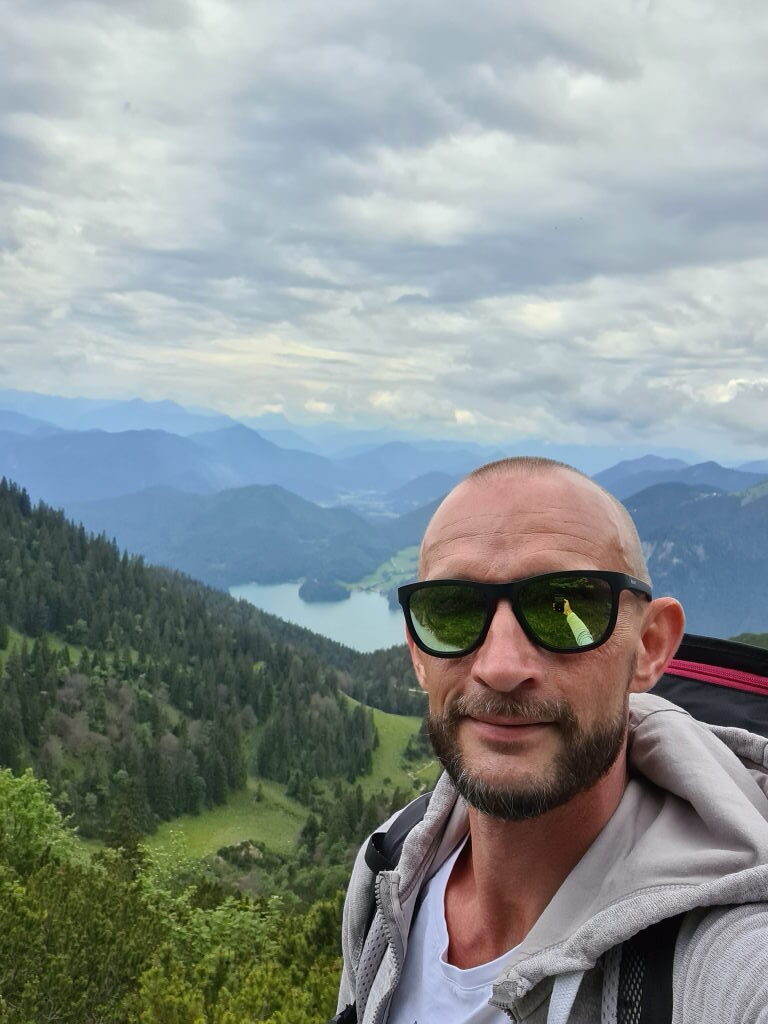 Selfie am Herzogstand-Gipfel mit Walchensee im Hintergrund