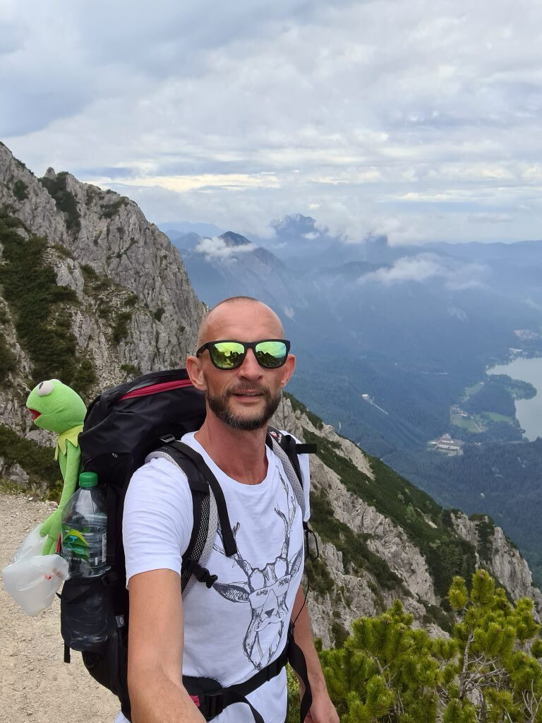 Sebastian mit Kermit am Rucksack auf dem Gratweg des Herzogstands mit Alpenpanorama
