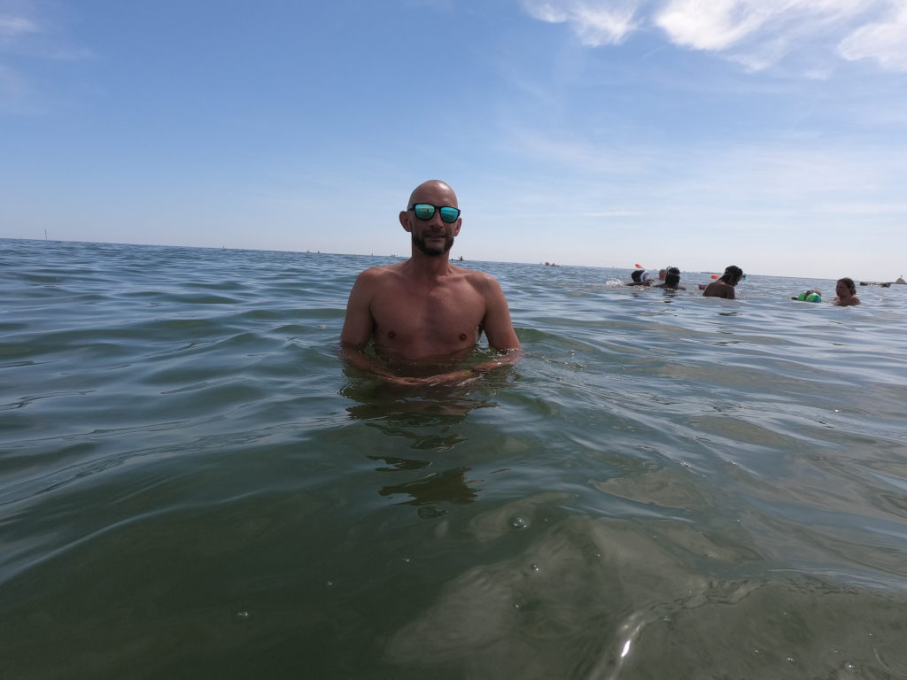 Sebastian steht im Meer beim Schwimmen an der Marina di Venezia, Cavallino-Treporti, August 2020