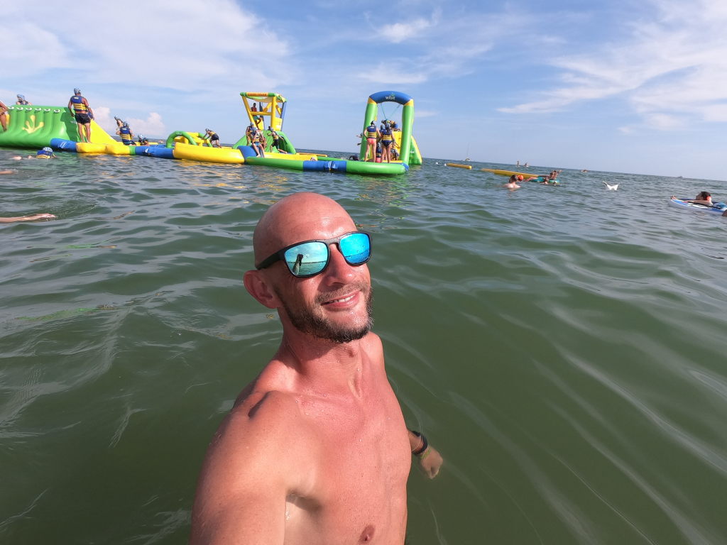 Sebastian im Meer mit aufgeblasenem Wasserpark im Hintergrund, Marina di Venezia, August 2020