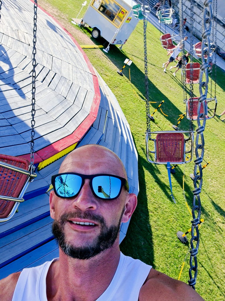 Sebastian Selfie im Kettenkarussell über der Theresienwiese München, Blick von oben auf die Gondeln, August 2020