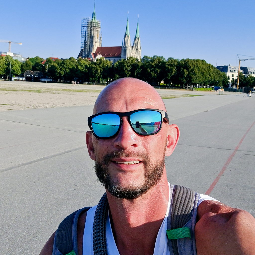 Sebastian Selfie auf der Theresienwiese München, St. Paul Kirche im Hintergrund, weite leere Fläche, August 2020