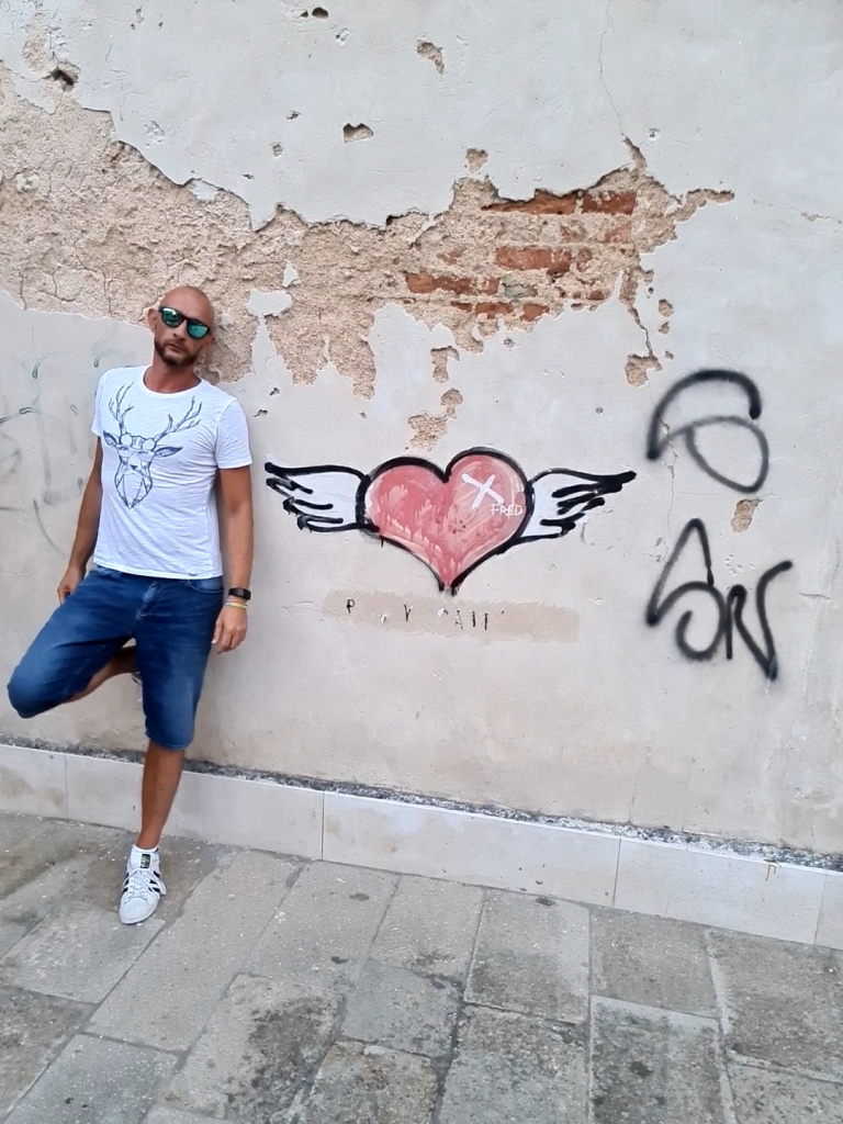 Sebastian neben Street-Art-Herz-Graffiti an einer Hauswand in Venedig, August 2020