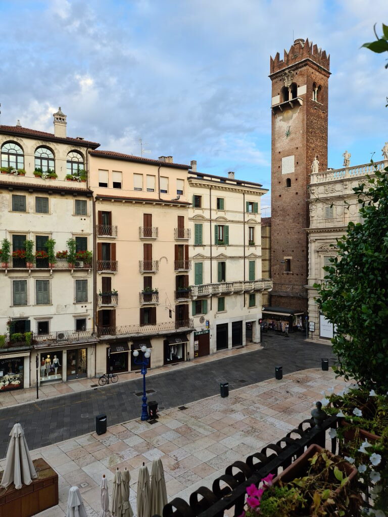 Blick vom Balkon über die fast leere Piazza Erbe in Verona am frühen Morgen mit Torre del Gardello