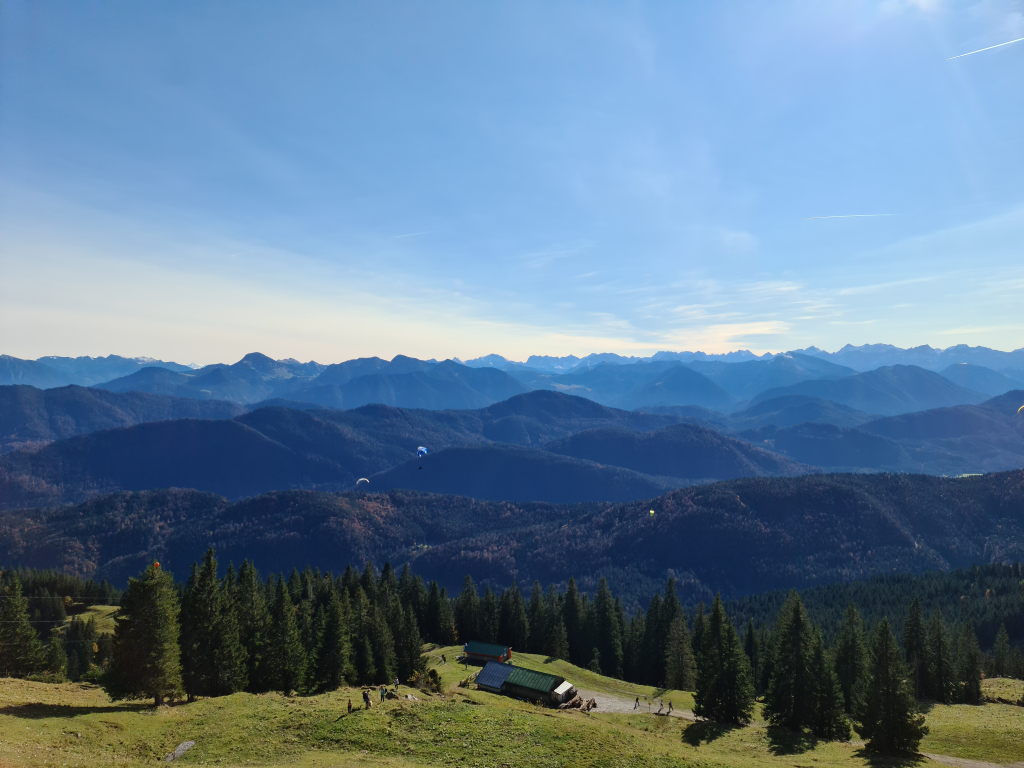 Panoramablick vom Brauneck-Gipfel mit Paragleitern über den Bayerischen Alpen im Oktober 2020