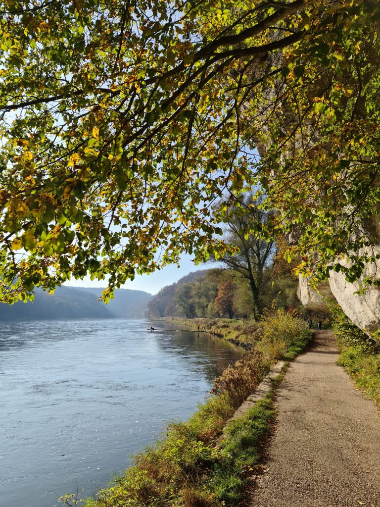 Uferweg am Donaudurchbruch unter Kalkfelsen, Herbst, andere Wanderer in der Ferne, November 2020