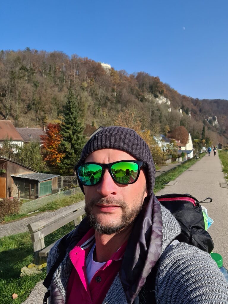 Selfie am Uferweg Kelheim, im Hintergrund bewaldeter Fels mit Befreiungshalle, blauer Himmel, November 2020