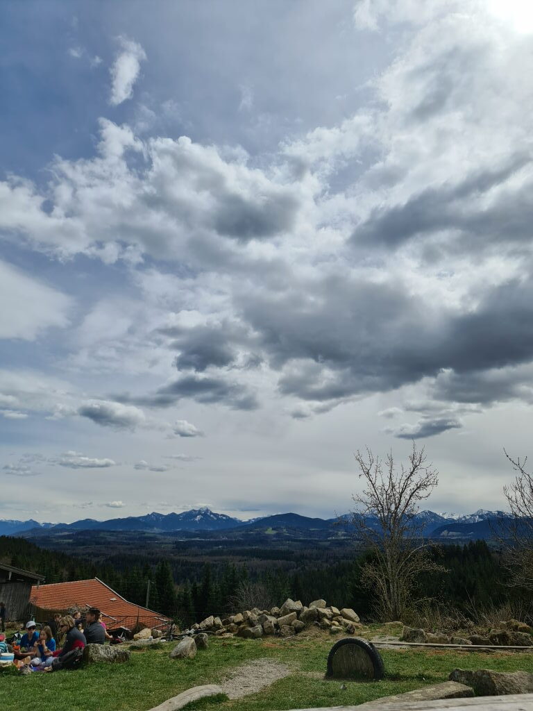 Weite Aussicht vom Taubenberg auf das Alpenvorland und die verschneiten Alpen im April