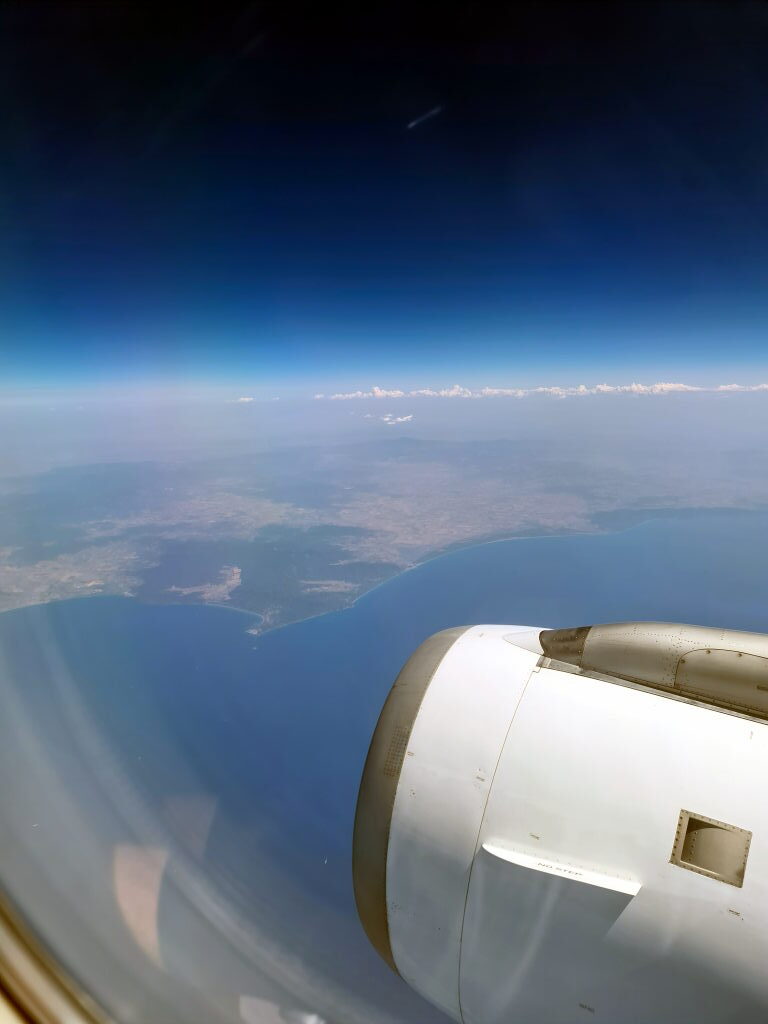Blick aus dem Flugzeugfenster auf die Küste Sardiniens und die Bucht von Olbia beim Abflug