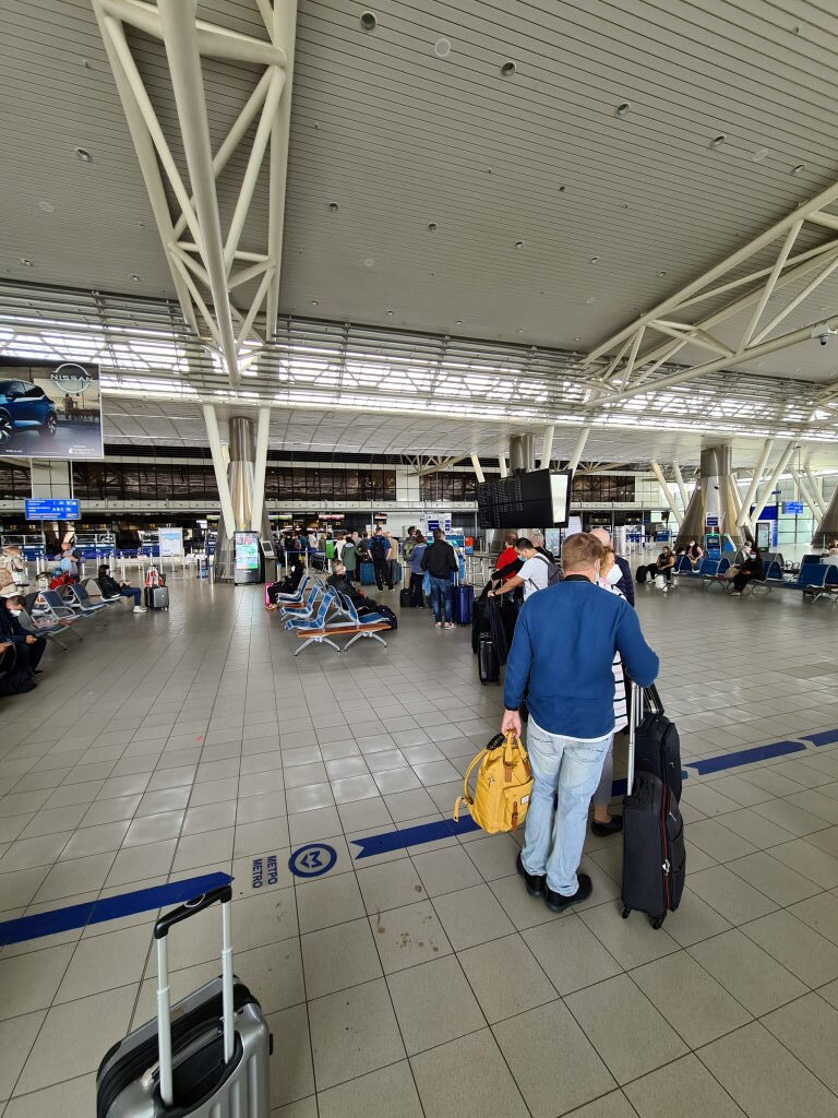 Check-in-Bereich des Sofia International Airport mit langer Schlange und Reisenden mit Gepäck