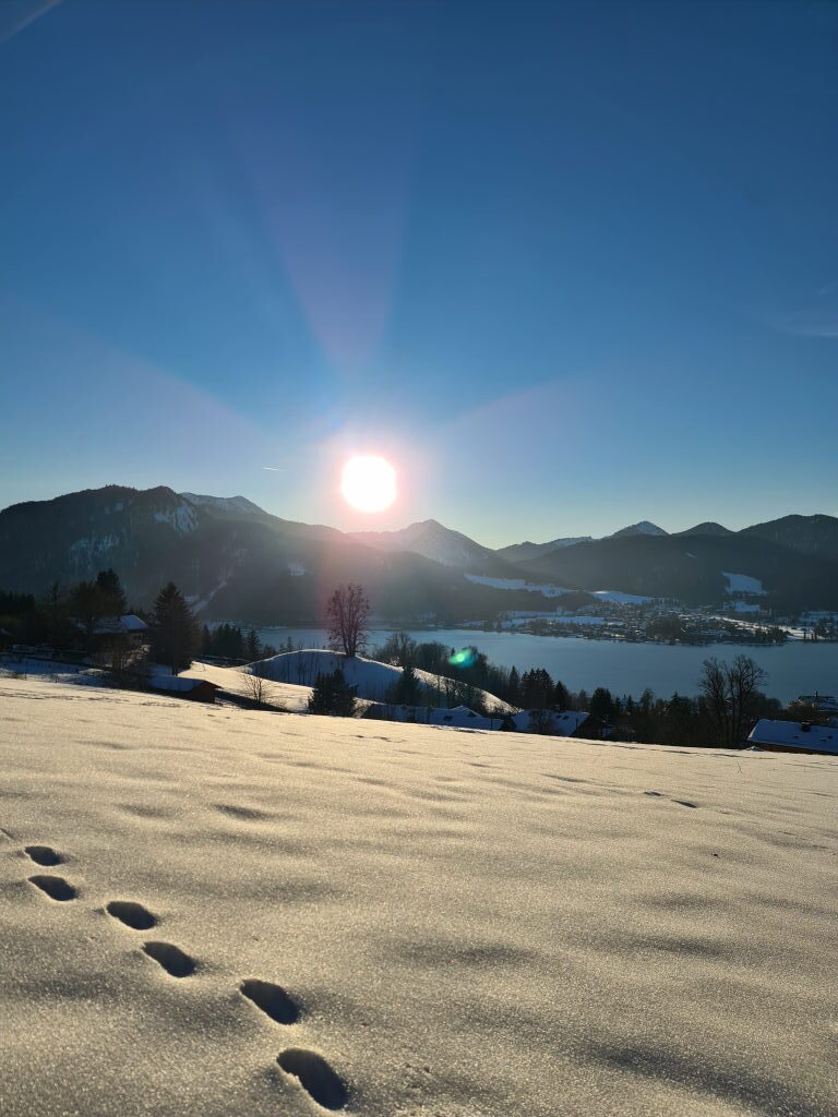 Winterpanorama Tegernsee mit Blick auf den See und Berge im Gegenlicht Januar 2022