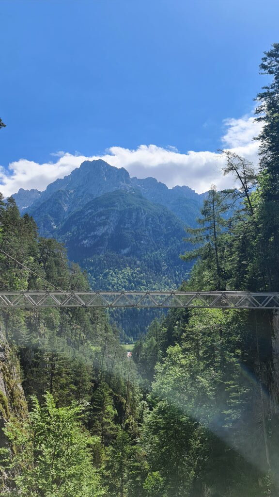 Panoramabrücke über die Geisterklamm mit Blick auf Bergmassiv und bewaldete Hänge
