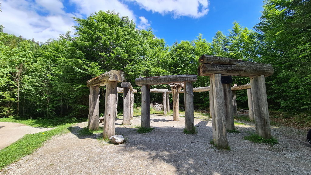 Holzkonstruktion aus dicken Baumstämmen im Stil von Stonehenge auf einer Lichtung im Wald bei Mittenwald