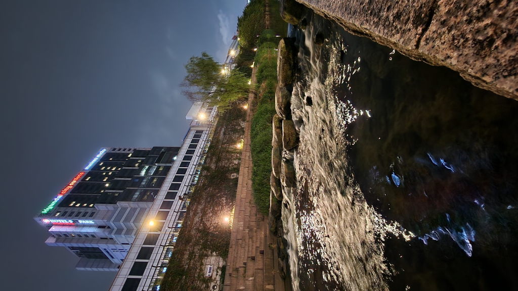 Cheonggyecheon bei Nacht mit Hyundai Gebäude