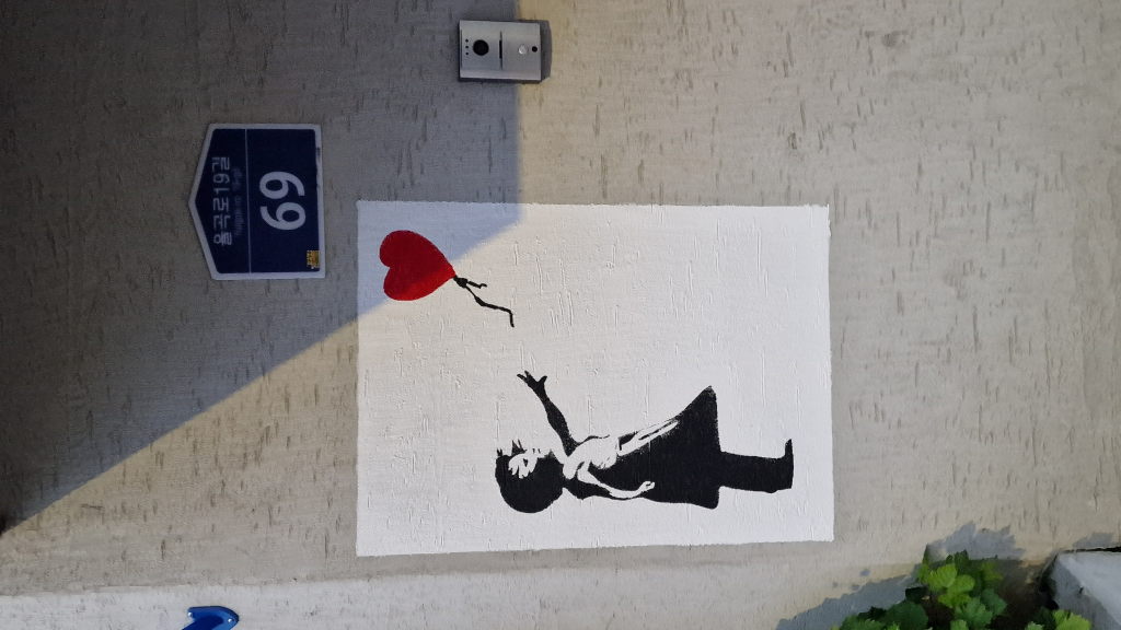 Banksy Variation Mädchen mit Ballon an Hauswand Seoul