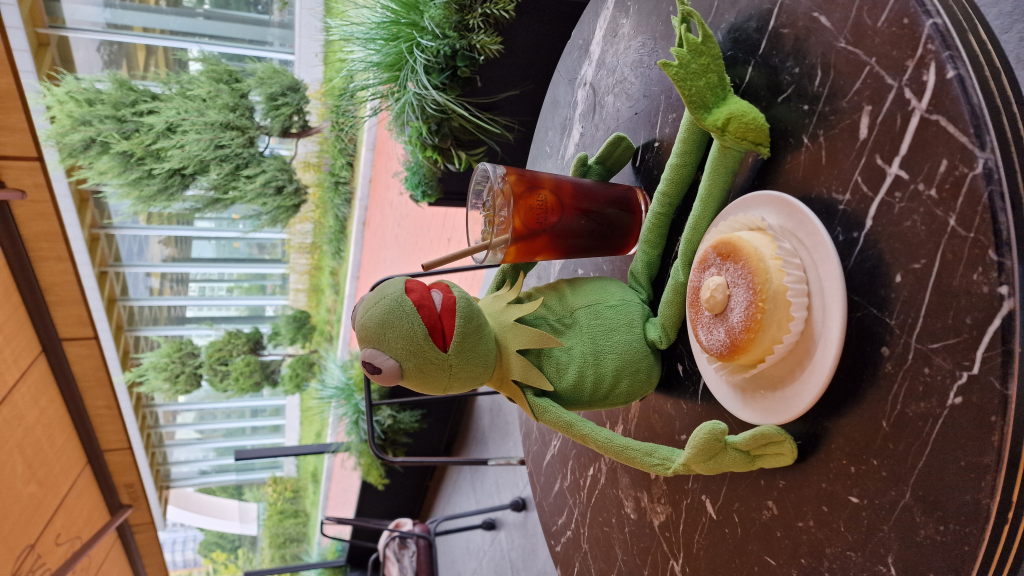 Kermit mit Cheesecake und Eiskaffee im Olympic Park Café